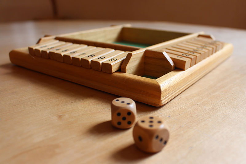 Ein Holzwürfelspiel mit Zahlen steht auf einem Tisch